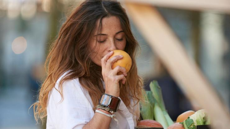 woman sniffing orange