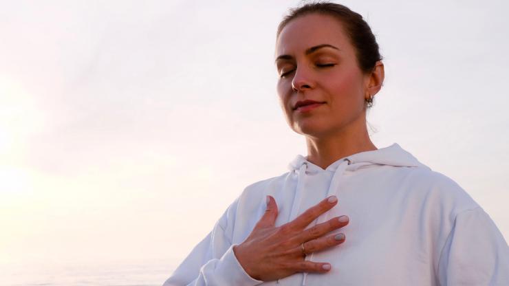 woman with hand over chest