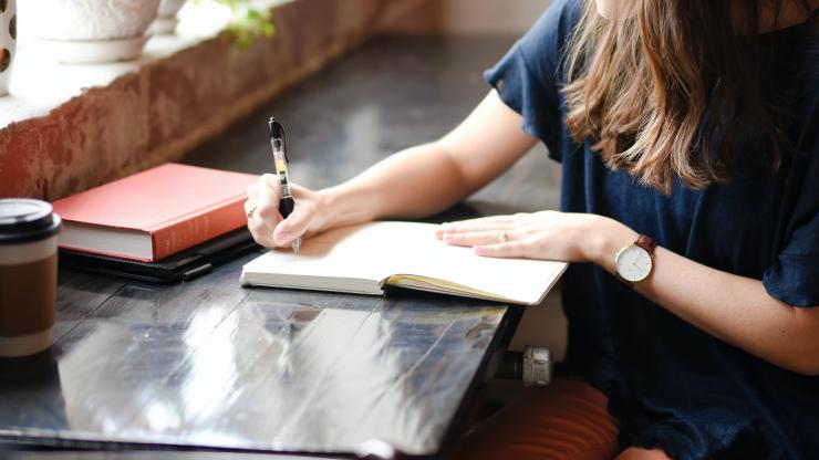 woman writing at window