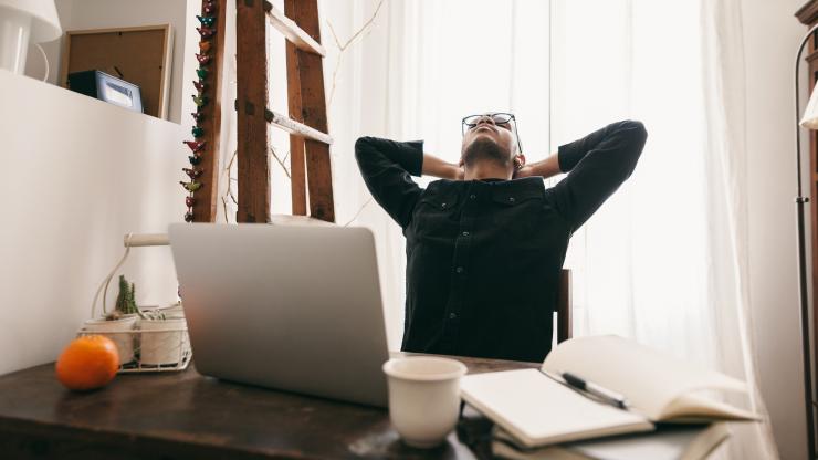 man stretching at computer