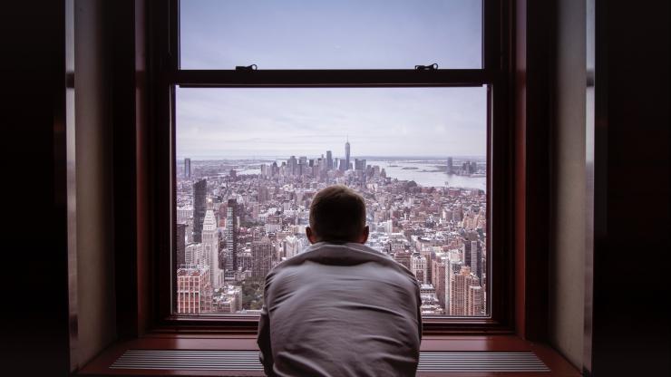 man looking out window nyc