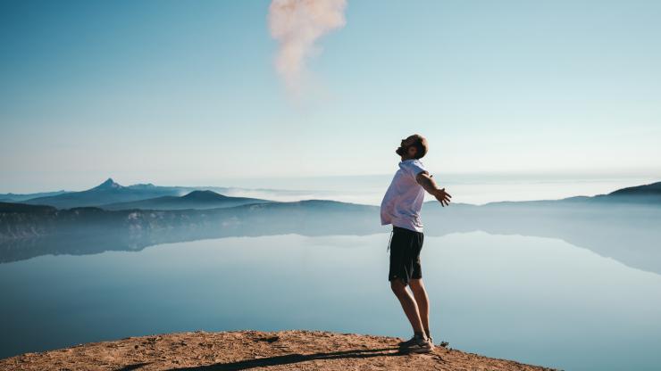 Guy on a cliff with arms outspread