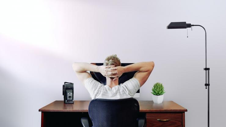 Guy sitting at desk with hands on his head