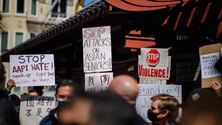 People at a protest hold up signs that say "Stop AAPI Hate," "Stop Attacks on Asian Seniors" and "Stop Violence"
