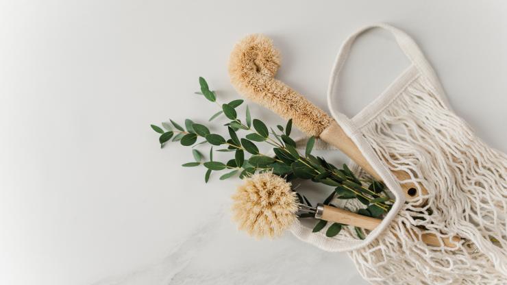 Eco-friendly dish scrubber in a reusable mesh fabric bag with eucalyptus leaves