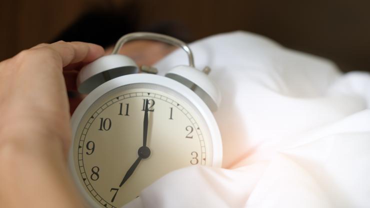 Hand reaches for an alarm clock