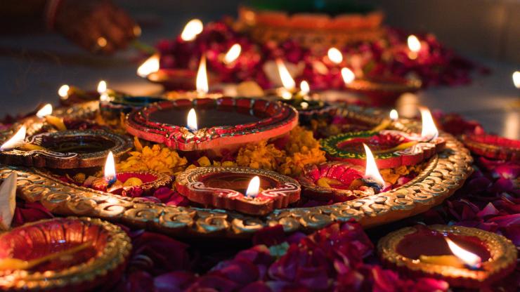 Candles and colorful flowers laid out for Diwali