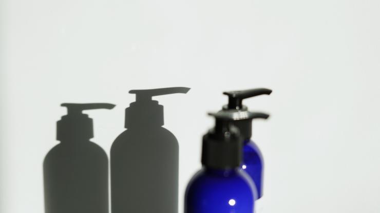 Blue plastic bottles with a shadow on the wall behind them