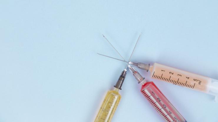 Three syringes with different colored liquids overlap.