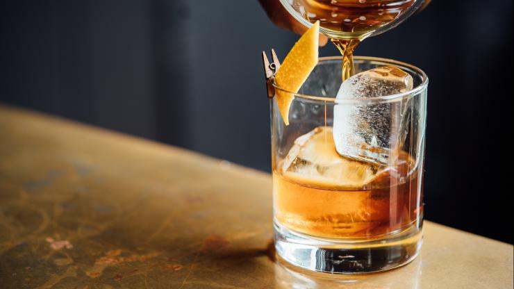 Chai mocktail being poured into a glass with ice.